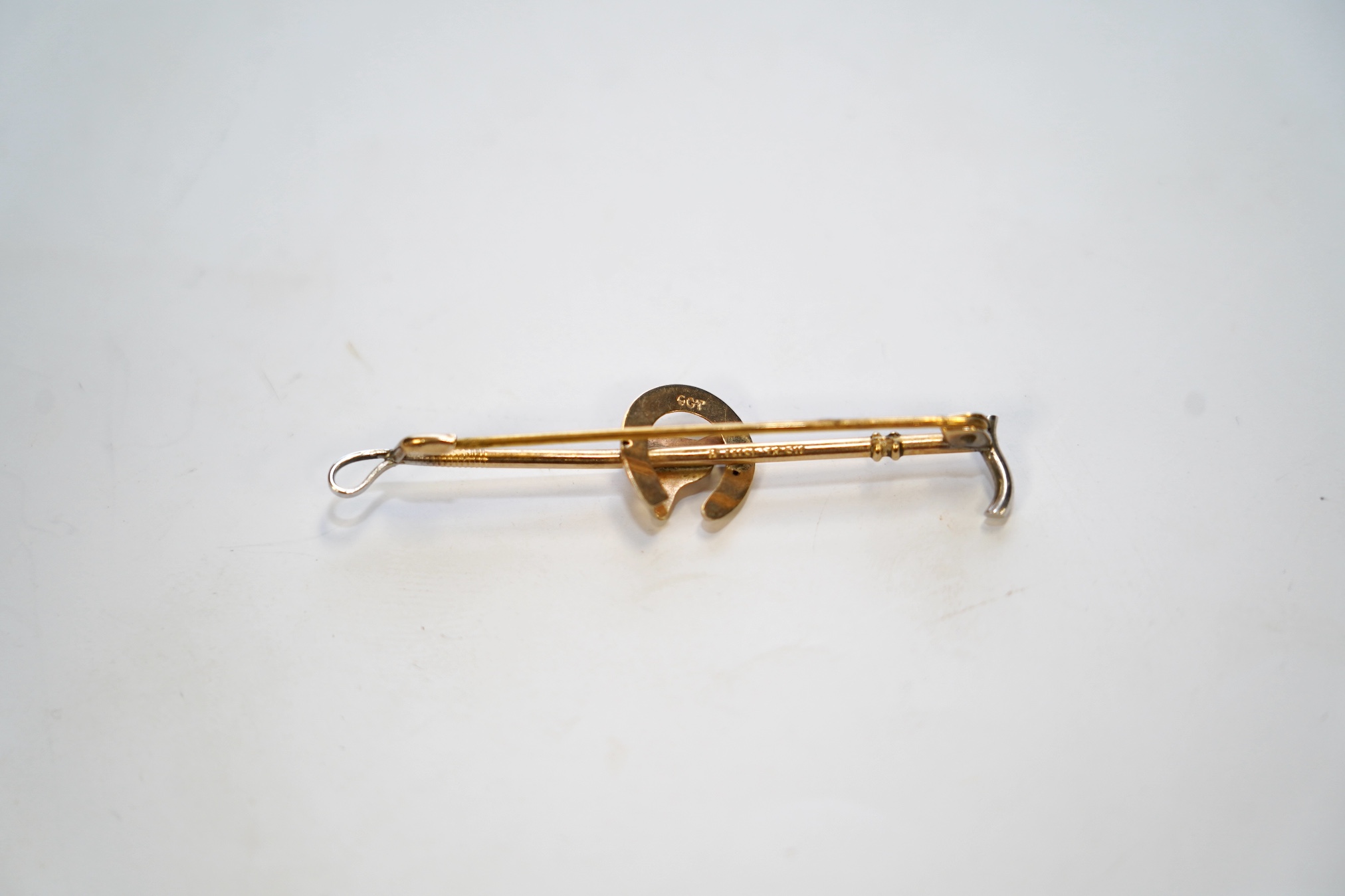 A 9ct and white metal fox head and riding crop tie pin, 56mm, gross weight 2.5 grams. Condition - good